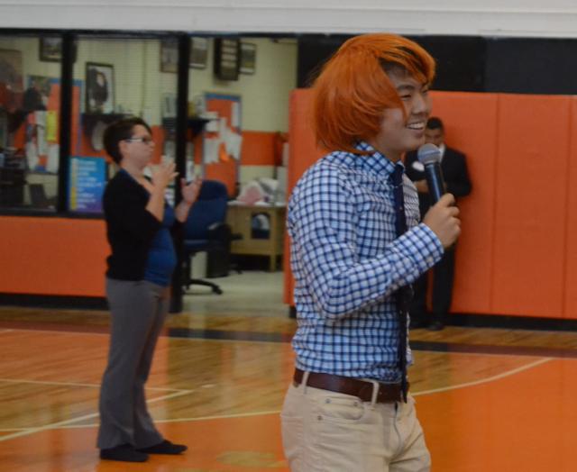 Shawn Kim wears an orange wig during his speech
