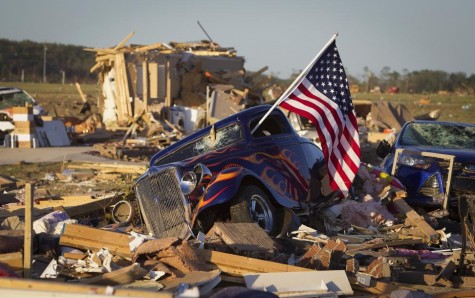 A U.S. flag sticks out the window of a damaged hot rod car in a suburban area after a tornado near Vilonia, Arkansas, April 28, 2014