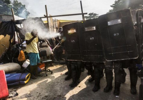 Riot police use pepper gas against residents of the Telerj slum as they attempt to repossess the land in Rio de Janeiro, April 11, 2014.