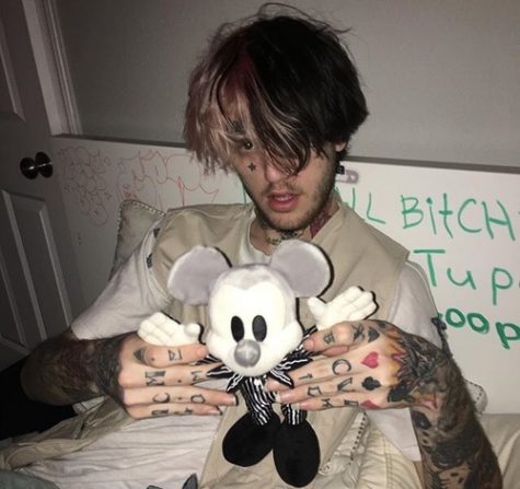Lil Peep is holding a toy.